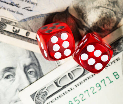 Two red dices on an American one hundred dollar bill.