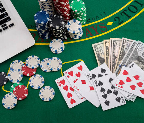 poker chips with banknotes placed on a laptop keyboard. Poker concept